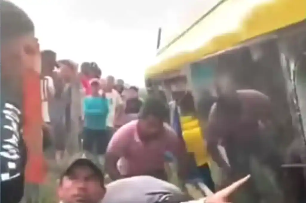 Passageiros feridos, incluindo idosos, observam um ônibus branco tombado na lateral de uma rodovia rural no Pará.