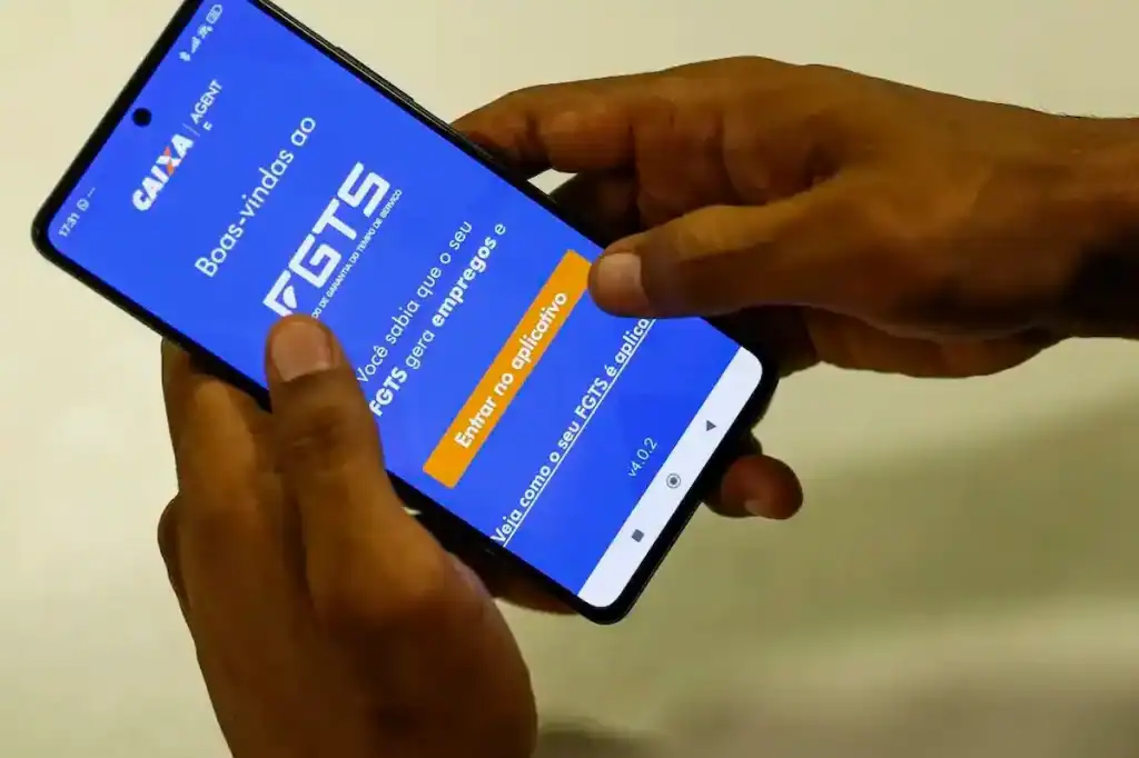 Trabalhador analisando tela de celular com opções de linha de crédito e crédito